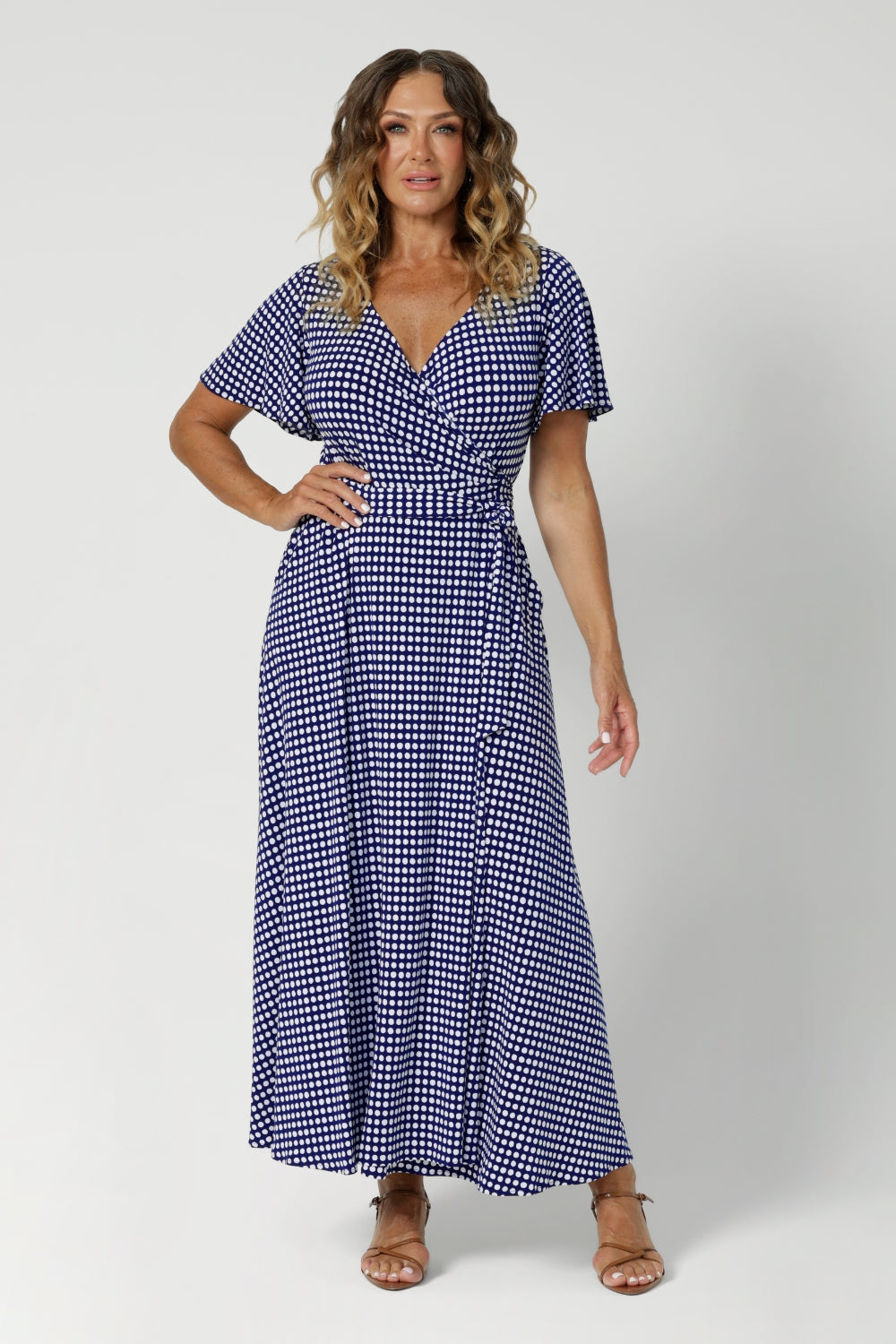 Size 12 woman wears A-line skirt that drapes beautifully, providing both comfort and movement. Maxi dress is designed with practical side pockets for practicality and functioning wrap adds to the dresses styling versatility. Leina & Fleur crafts dresses in sizes 8-24.