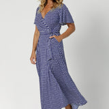 Over 40's model wears polka dot wrap dress. Falling at maxi skirt length, it offers an elegant, floor-length look, perfect for any off duty occasion. Leina & Fleur Australian designer created womans clothing in sizes 8-24.