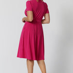 A back image of a woman in her 40s wearing a wrap dress in pink by australian made womens clothing brand Leina & Fleur. 