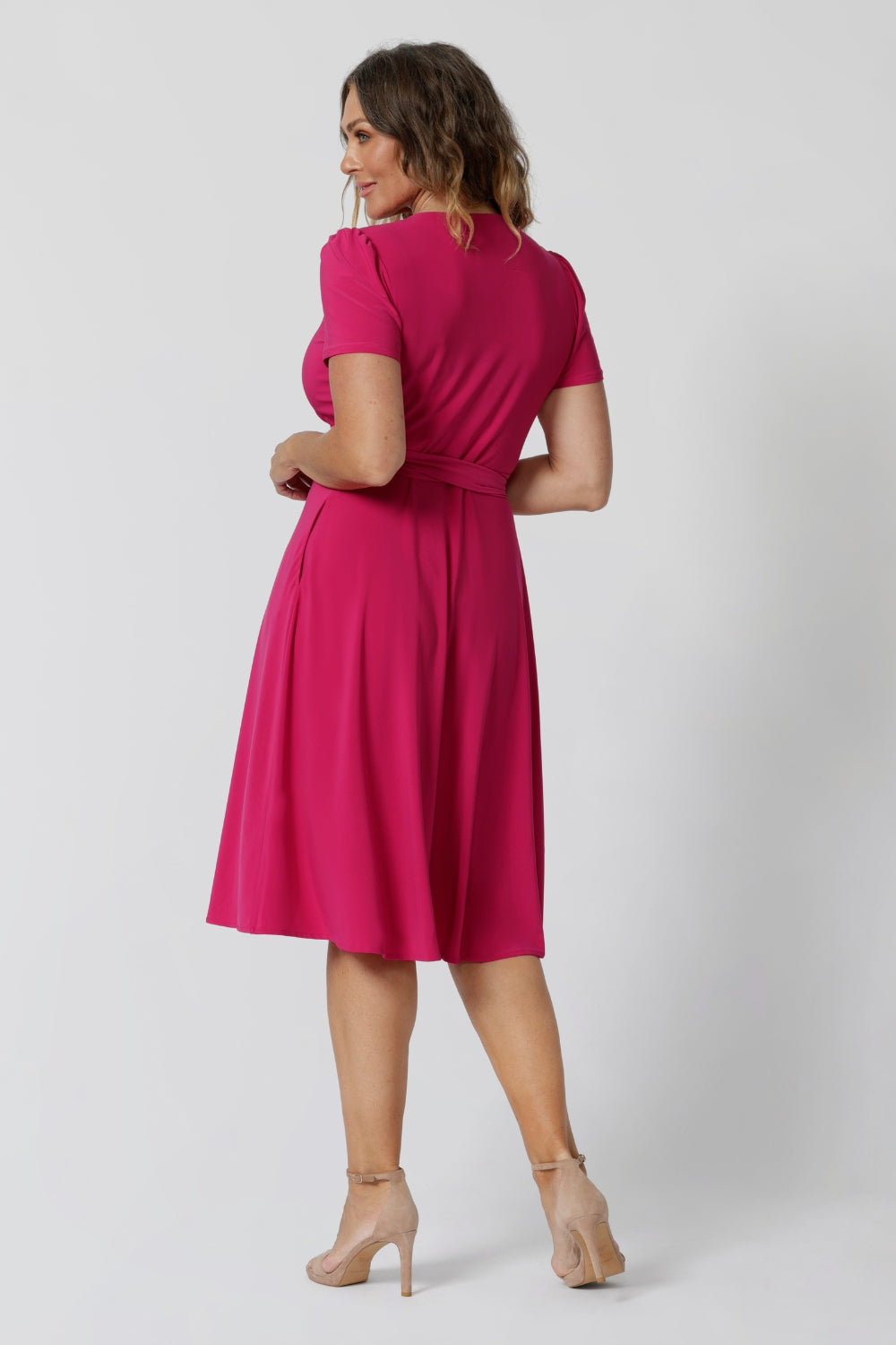 A back image of a woman in her 40s wearing a wrap dress in pink by australian made womens clothing brand Leina & Fleur. 