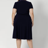 Workwear staple for the women on the go. Plus size model wears navy coloured wrap dress. Made from heavy weight dry touch jersey. Shop made in Australia dresses in petite to plus sizes online at Australian Leina & Fleur in sizes 8-24.