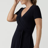  Close up of an over 40, size 10 wearing a navy, wrap dress with short sleeves. A great dress for summer casual wear, or for travel. Shop made in Australia dresses in petite to plus sizes online at Australian fashion brand, Leina & Fleur.