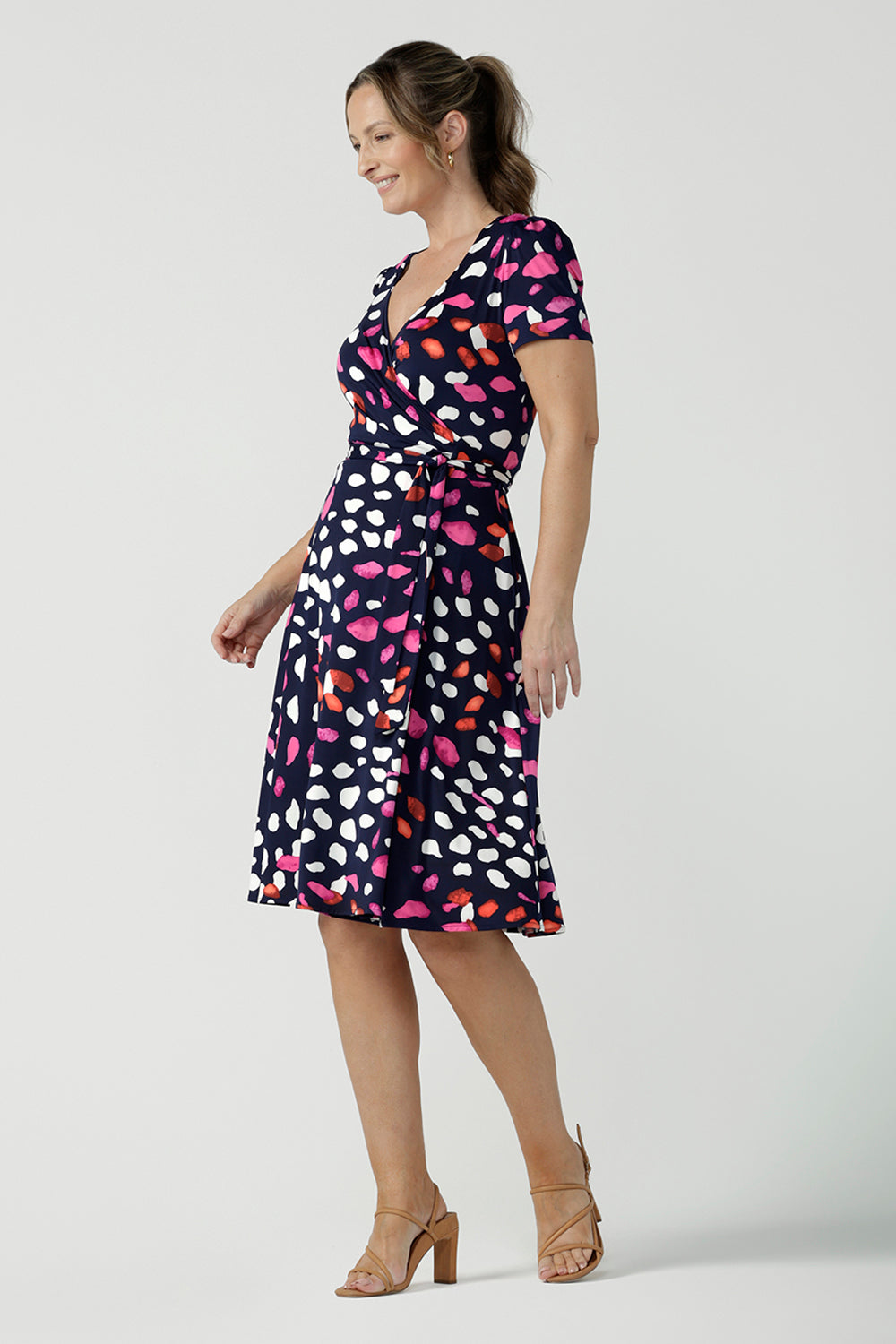  An over 40, size 10 woman wearing a abstract jersey print, knee length wrap dress with short sleeves. A great dress for summer casual wear, or for travel. Shop made in Australia dresses in petite to plus sizes online at Australian fashion brand, Leina & Fleur.
