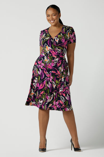 Size 16 woman wears the Maree dress in Vivid Flora. Short sleeve functioning wrap dress. Knee length dress great for petite heights. Work corporate to weekend wear. Travel friendly. Made in Australia for women size 8 - 24.