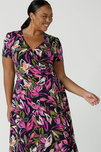 Close up of a size 16 woman wears the Maree dress in Vivid Flora. Short sleeve functioning wrap dress. Knee length dress great for petite heights. Work corporate to weekend wear. Travel friendly. Made in Australia for women size 8 - 24.