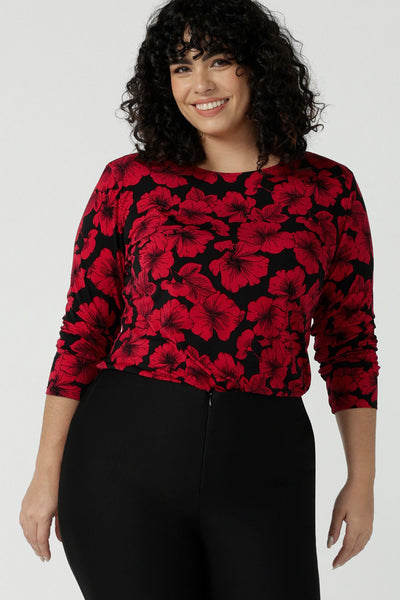 Size 18 woman wears the Mason top in Bold Poppy . A long sleeve jersey top for women with red floral on a black base. Comfortable work top for women size 8 - 24. Soft jersey fabric and made in Australia for women. 