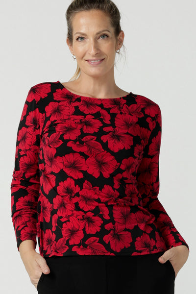 Size 10 woman wears the Mason top in Bold Poppy . A long sleeve jersey top for women with red floral on a black base. Comfortable work top for women size 8 - 24. Soft jersey fabric and made in Australia for women. Styled back with Black Brooklyn slim fit pants and black heels and Garcia ponte jacket.