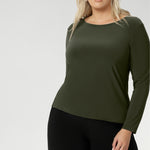 Perfect layering top as the weather cools. The close-to-body fit is enhanced by bust darts for a flattering silhouette, while long sleeves offer warmth. The straight hemline at the front and longer curved hemline at the back add a modern touch to this versatile piece. Available in sizes 8 to 24. Plus size woman wears her top with wide leg black pants. 