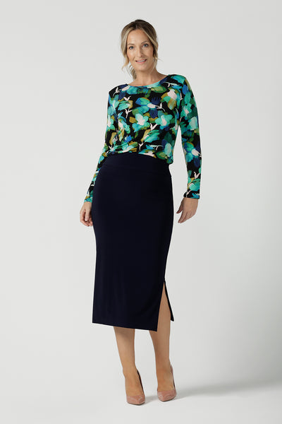 A size 10 woman wears the Mason top in Canopy, a green watercolour print top with a green watercolour splatter print. Styled back with a navy Andi Midi skirt. Made in Australia for women size 8 - 24.