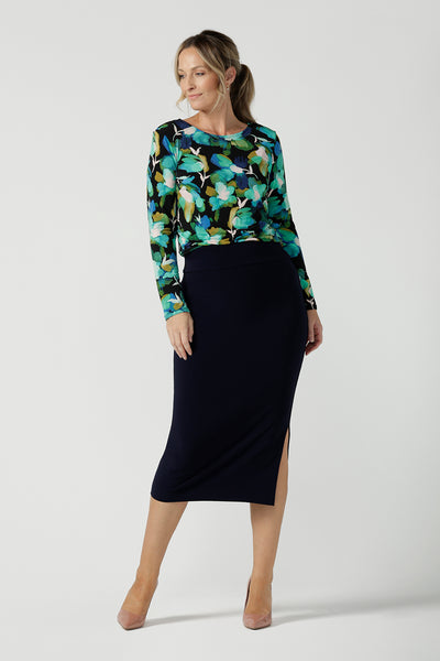 A size 10 woman wears the Mason top in Canopy, a green watercolour print top with a green watercolour splatter print. Styled back with a navy Andi Midi skirt. Made in Australia for women size 8 - 24.