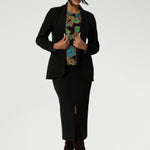 Size 10 woman wears her floral top paired with midi length skirt and black easy care blazer. The long sleeves provide added warmth, while the straight hemline at the front and curved hemline at the back, which sits longer, give it a modern touch. 