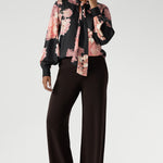 While the fabric offers no stretch, its fluid drape ensures a flattering, comfortable fit. Ideal for pairing with tailored separates or dressed down with denim, the Matisse Shirt brings timeless romance to your wardrobe. Plus size woman wears floral blouse tucked into her straight leg pants. 