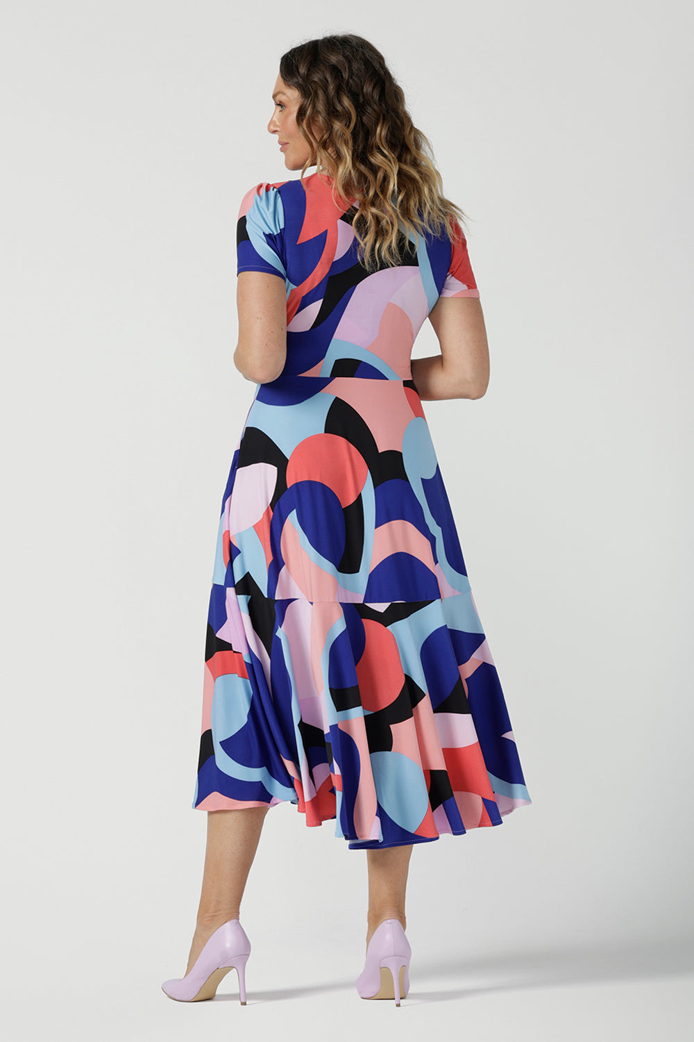 Back of The Mavi Dress in Amalfi is a fixed wrap dress in midi length. A abstract print with a short sleeve. Based on our best selling Bettina dress, this style is great to take you from desk to dinner. Petite to plus size women size 8-24.