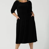 Size 18 woman wears the Melissa dress in black, a belted style with pockets and 3/4 sleeve with rounded boat neckline. Petite to plus size fashion made in Australia for women size 8 - 24. 