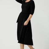 Size 10 woman wears the Melissa dress in black, a belted style with pockets and 3/4 sleeve with rounded boat neckline. Petite to plus size fashion made in Australia for women size 8 - 24.