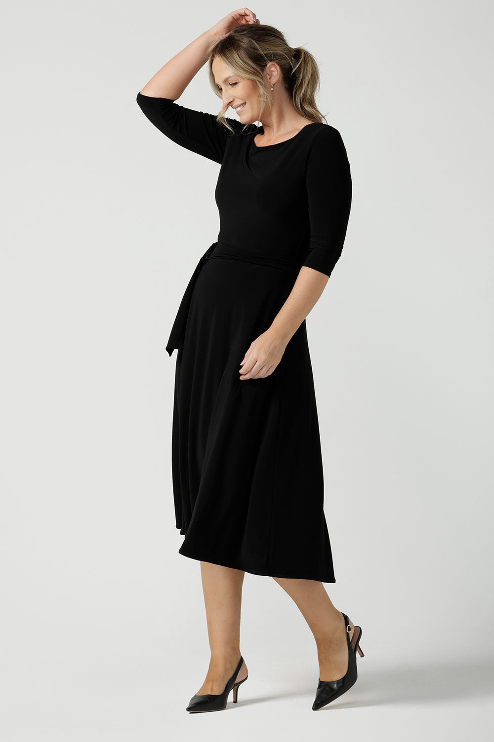 Size 10 woman wears the Melissa dress in black, a belted style with pockets and 3/4 sleeve with rounded boat neckline. Petite to plus size fashion made in Australia for women size 8 - 24.