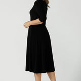 Back view of a size 10 woman wears the Melissa dress in black, a belted style with pockets and 3/4 sleeve with rounded boat neckline. Petite to plus size fashion made in Australia for women size 8 - 24.