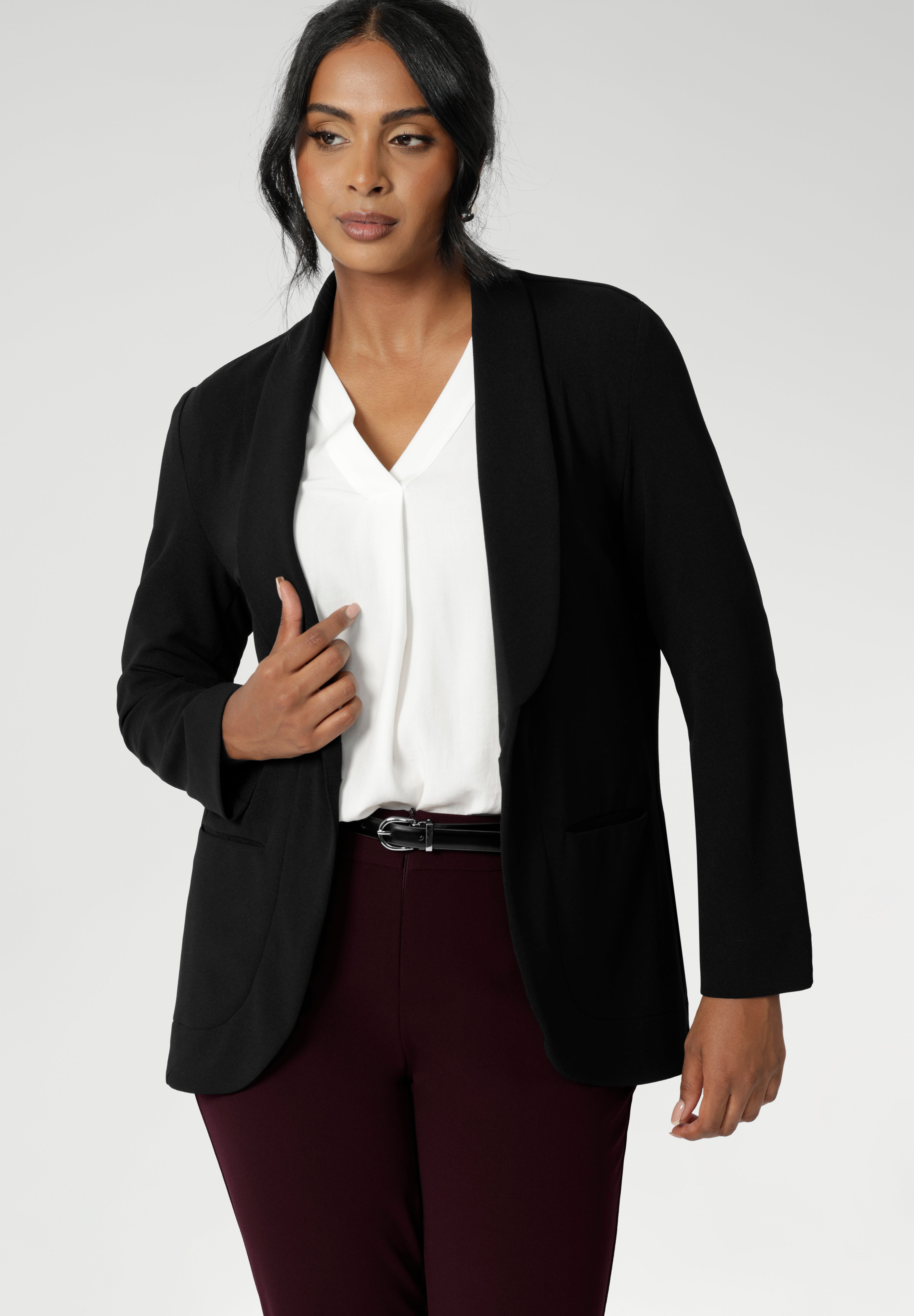 30 year old woman wears tailored black blazer made of soft stretch scuba crepe fabric. Easy care blazer is a staple for any wardrobe. Black work wear blazer provides the perfect blend of work wear and off-duty style. Australia made clothing brand Leina & Fleur. Shop Soft Suiting in sizes 8-24. 