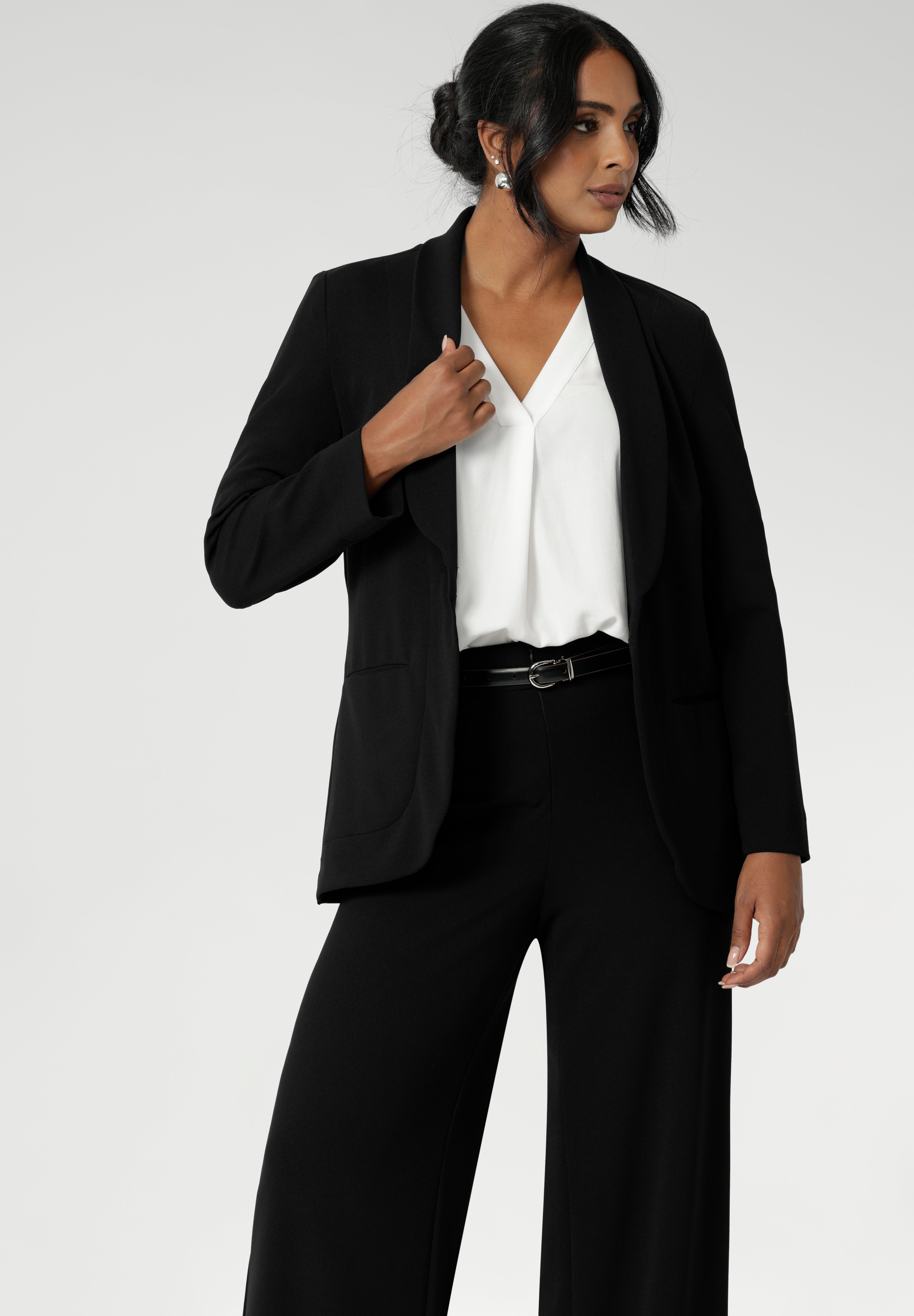 Leina & Fleur's model wearing black workwear blazer. Designed for modern professionals who value functionality and comfort. Woman's fashion brand Leina & Fleur stock soft suiting in sizes 8 to 24. Find this easy care work blazer and matching suit pants in plus size and petite sizes.