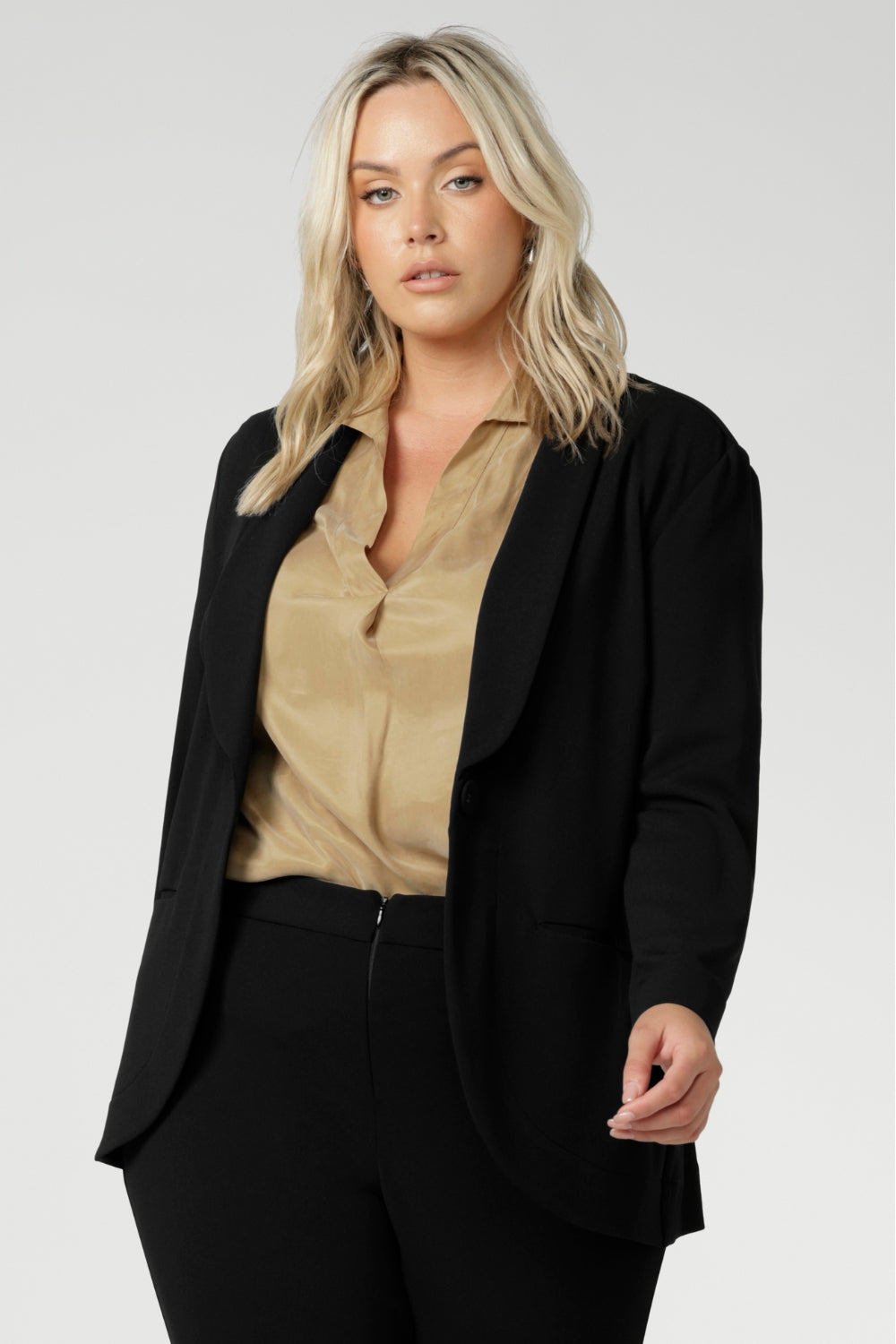 Leina & Fleur's model wearing black workwear blazer. Designed for modern professionals who value functionality and comfort. Woman's fashion brand Leina & Fleur stock soft suiting in sizes 8 to 24. Find this easy care work blazer and matching suit pants in plus size and petite sizes.