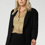 Leina & Fleur's model wearing black workwear blazer. Designed for modern professionals who value functionality and comfort. Woman's fashion brand Leina & Fleur stock soft suiting in sizes 8 to 24. Find this easy care work blazer and matching suit pants in plus size and petite sizes.