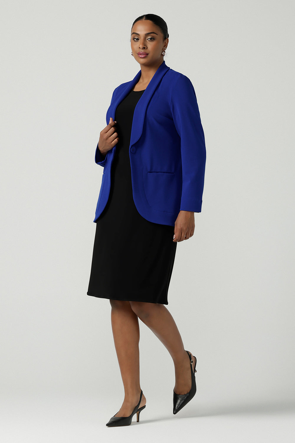 A size 10 model wears the Merit Blazer in Cobalt, a corporate casual blazer suit set made for women size 8-24. Styled back with matching Corbin Pant in Cobalt. Made in Australia for women size 8-24.