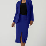 A size 10 woman wears the Aaron Mid Skirt in Cobalt Crepe back with the Black Ziggy Top. Made in Australia for women size 8-24. Comfortable corporate wear for women. Suit Sets in Cobalt. Easy care material. Petite to Plus Size women. Styled back with the Merit Blazer in Cobalt.