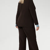 Merit is a tailored and light weight woman's workwear blazer that offers elevated style. Size 18 woman wears workwear blazer in cocoa colour, crafted from quality scuba crepe fabric. Long blazer offers full body stretch and comfort. Australia made by Leina & Fleur in sizes 8-24.