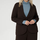 Merit is a tailored and light weight woman's workwear blazer that offers elevated style. Size 18 woman wears workwear blazer in cocoa, crafted from quality scuba crepe fabric. Long blazer offers full body stretch and comfort. Australia made by Leina & Fleur in sizes 8-24.