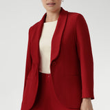 Plus size woman wears the Merit Blazer in Flame, a textured scuba crepe blazer with button front. This red work blazer is worn with red workwear pants and red cami top. Curved hemline and front pockets. Made in Australia for women size 8 - 24.