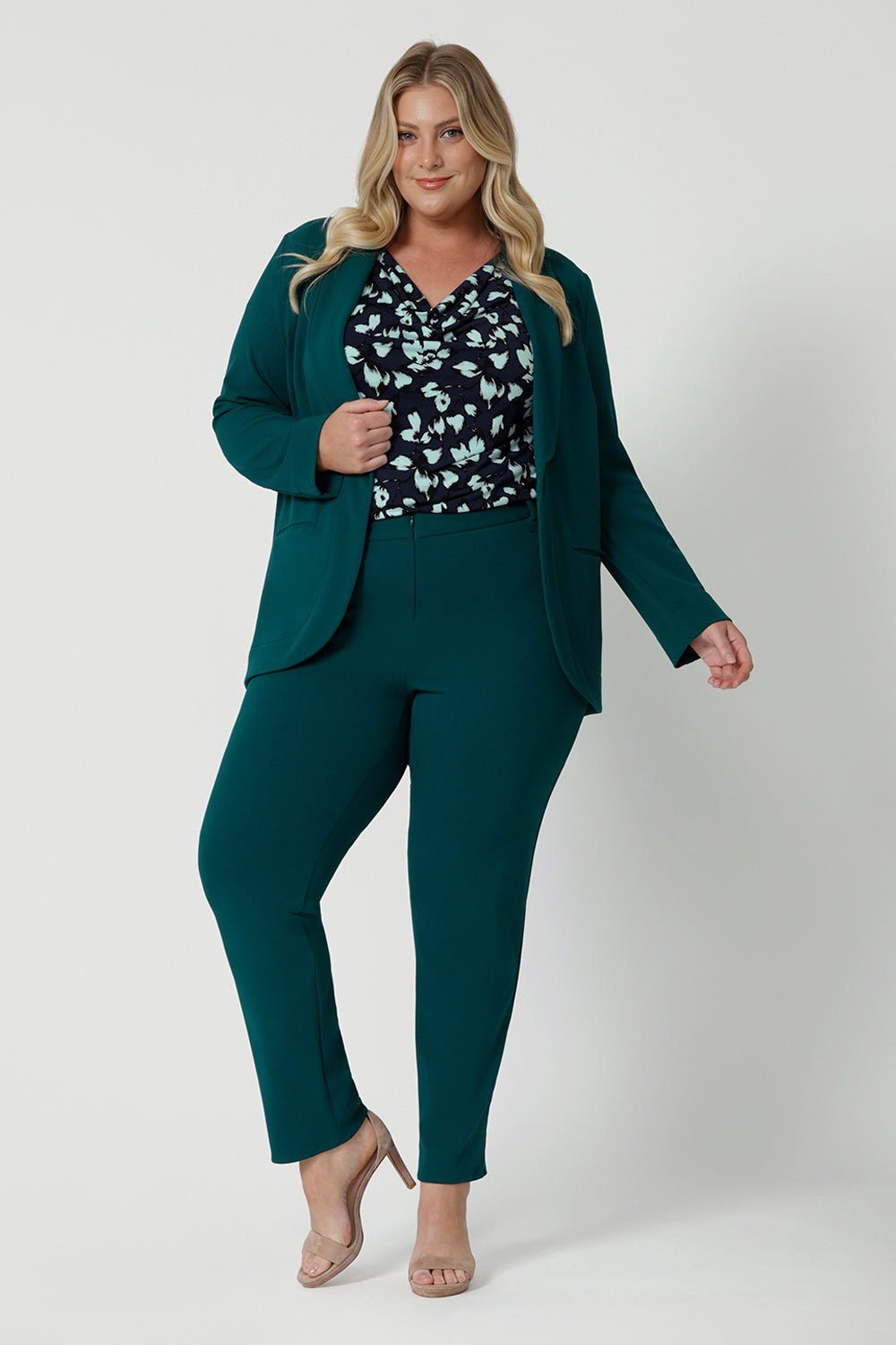 A good workwear outfit for plus size women, green, tapered leg pants are worn with a green workwear blazer and jersey cowl neck top. Shown on a size 18 woman, this is plus size workwear suit is made in Australia by Australia and New Zealand women's clothes brand Leina & Fleur. 