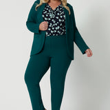 A good workwear outfit for plus size women, green, tapered leg pants are worn with a green workwear blazer and jersey cowl neck top. Shown on a size 18 woman, this is plus size workwear suit is made in Australia by Australia and New Zealand women's clothes brand Leina & Fleur. 