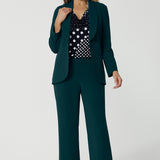 Showing good workwear for over 50s women, a Green scuba crepe suit is worn with a navy and white spot print jersey top. This longline women's work blazer and wide leg work pants are made in Australia by Australia and New Zealand women's clothes brand, Leina & Fleur. Available to shop in sizes 8 to 24, this is workwear for plus size to petite height women. 