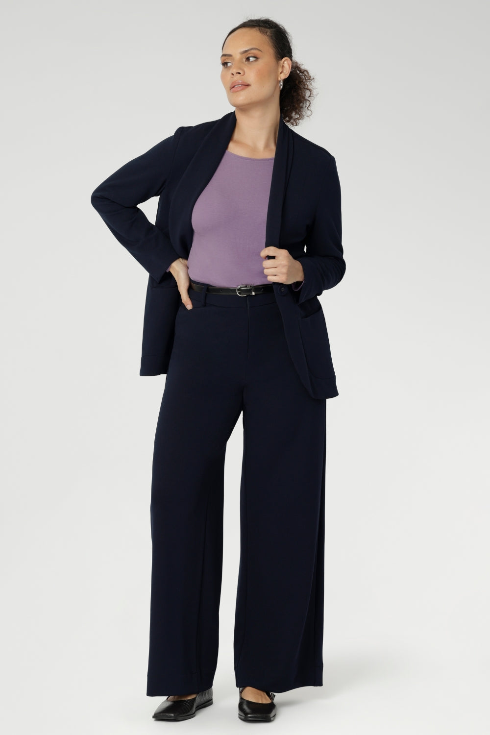 Size 10 women wearing a Navy Merit blazer with Scuba crepe and collar. It has functional patch pockets and tailored shawl collar. Stylish corporate casual wear for women. Made in Australia size 8 - 24.
