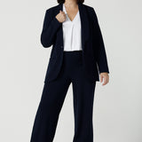 Size 10 women wearing a Navy Marit blazer with Scuba crepe and collar. It has functional patch pockets and tailored shawl collar. Stylish corporate casual wear for women. Made in Australia size 8 - 24.