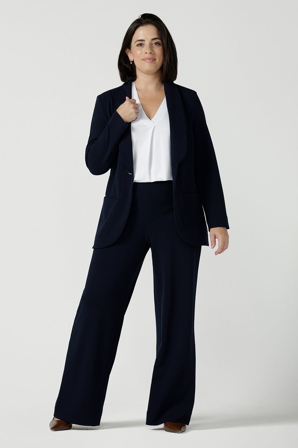 Size 10 women wearing a Navy Marit blazer with Scuba crepe and collar. It has functional patch pockets and tailored shawl collar. Stylish corporate casual wear for women. Made in Australia size 8 - 24.