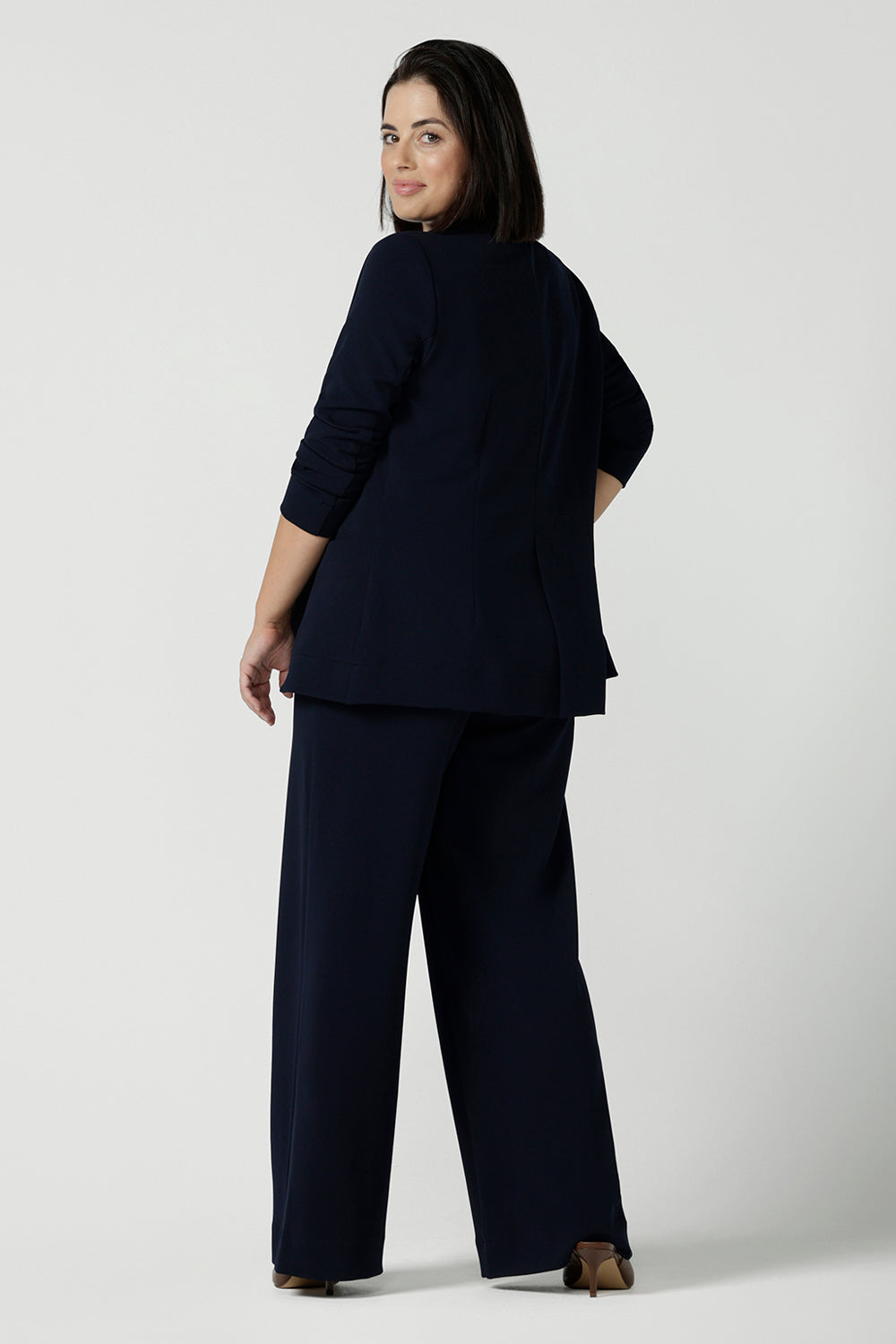 Back view of a size 10 women wearing a Navy Marit blazer with Scuba crepe and collar. It has functional patch pockets and tailored shawl collar. Stylish corporate casual wear for women. Made in Australia size 8 - 24.