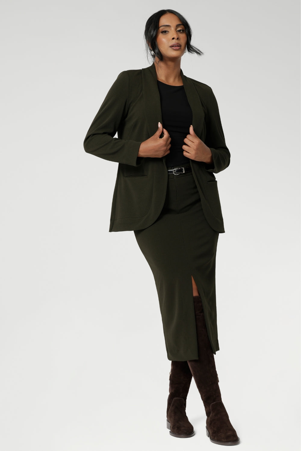 Womans easy care blazer made from Scuba crepe jersey fabric. Crafted with functional patch pockets, tailored shawl collar and covered front button. Woman's blazer will have you looking stylish in all corporate and casual occasions. Woman's workwear clothing made in Australia sizes 8-24. Size 10 woman wears her Olive Blazer with matching workwear midi length skirt.