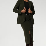 Womans easy care blazer made from Scuba crepe jersey fabric. Crafted with functional patch pockets, tailored shawl collar and covered front button. Woman's blazer will have you looking stylish in all corporate and casual occasions. Woman's workwear clothing made in Australia sizes 8-24. Size 10 woman wears her Olive Blazer with matching workwear midi length skirt.