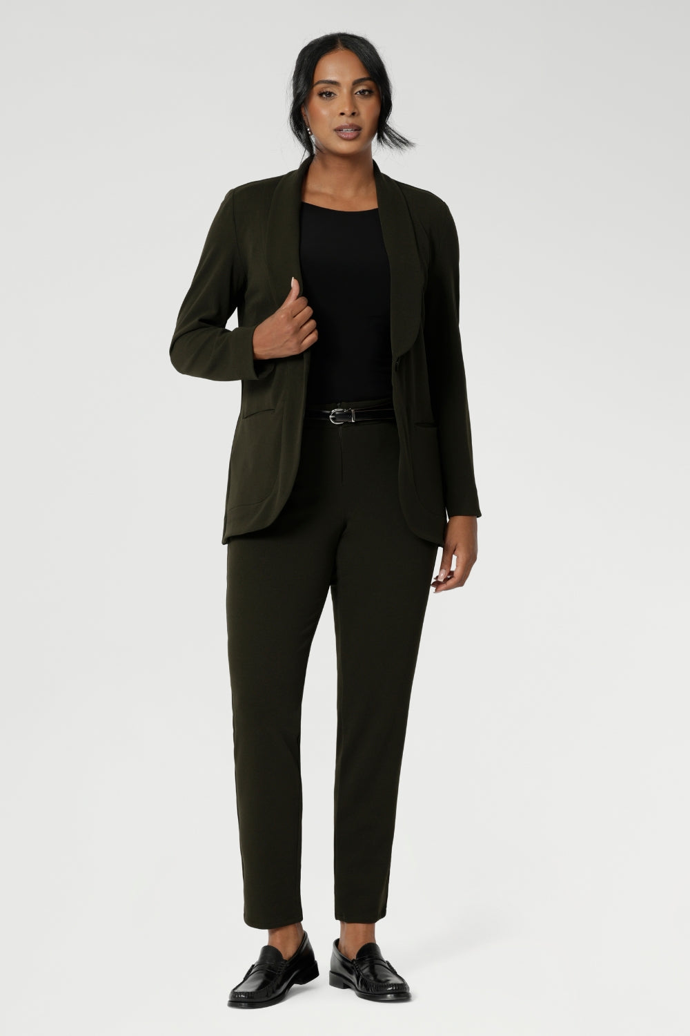 Womans easy care blazer made from Scuba crepe jersey fabric. Crafted with functional patch pockets, tailored shawl collar and covered front button. Woman's blazer will have you looking stylish in all corporate and casual occasions. Woman's workwear clothing made in Australia sizes 8-24. Size 10 woman wears her Olive Blazer with matching workwear tapered leg pants.