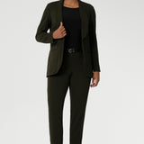 Womans easy care blazer made from Scuba crepe jersey fabric. Crafted with functional patch pockets, tailored shawl collar and covered front button. Woman's blazer will have you looking stylish in all corporate and casual occasions. Woman's workwear clothing made in Australia sizes 8-24. Size 10 woman wears her Olive Blazer with matching workwear tapered leg pants.