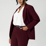 Merit is a tailored and light weight woman's workwear blazer that offers elevated style. Size 12 woman wears workwear blazer in deep wine colour, crafted from quality scuba crepe fabric. Long blazer offers full body stretch and comfort. Australia made by Leina & Fleur in sizes 8-24.