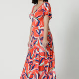 Side view of a good summer maxi dress for petite height women, this printed jersey dress has a twist front bodice and flutter sleeves. A dress for cruise holidays and resort style, this maxi dress is easy-care and crease-resistant. Made in Australian by Australian and New Zealand women's online clothes brand, Leina & Fleur, shop their cruise wear fashions online in sizes 8 to 24.