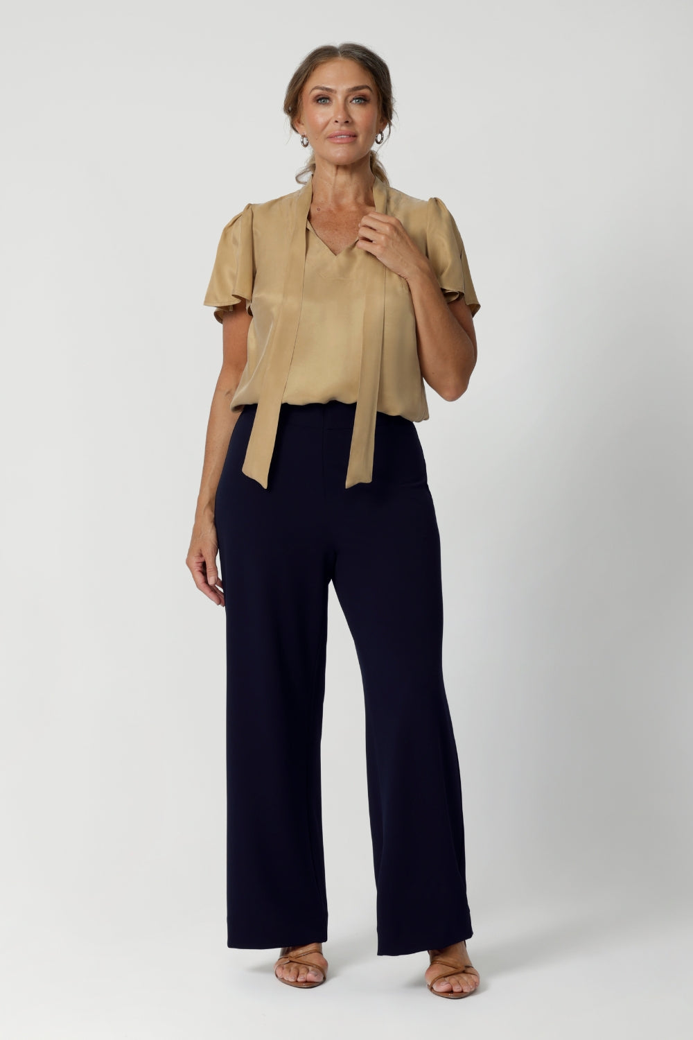 Workwear blouse seen on over 40's woman, offers endless mix-and-match possibilities with other pieces from our soft suiting or scuba collections. Neck ties are seen untied and the blouse untucked, creating a soft open tuxedo look. Michael Shirt in Gold is available in sizes 8-24 and in many colours and prints.