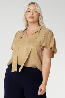 V-neckline blouse with delicate neckties adds a touch of feminine elegance, while allowing you to adjust the fit for added comfort and style. Workwear blouse also has short flutter sleeves with slits on the shoulders, that add a modern, airy feel to the blouse, giving it a subtle yet playful look.