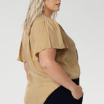 Image shows plus size woman wearing evening blouse, featuring a shirttail hemline. This women's blouse is versatile enough to be tucked into skirts or trousers for a polished look. Available in sizes 8-24 and exclusively online at Leina & Fleur, this shirt is the perfect addition to any wardrobe.