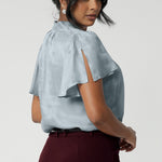 Made from a luxurious soft suede-touch Tencel fabric in a cool, serene Ice Blue colour. This women's blouse drapes beautifully on the body, creating a flattering and luminous effect. Breathable blouse features flutter sleeves with slits and shirttail hem.