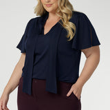 Close up image of plus size woman wearing navy work wear blouse. This top is navy in colour and has been designed using high quality easy care dry touch jersey material. Garments are Australian made by Leina + Fleur for Australian and New Zealand woman.