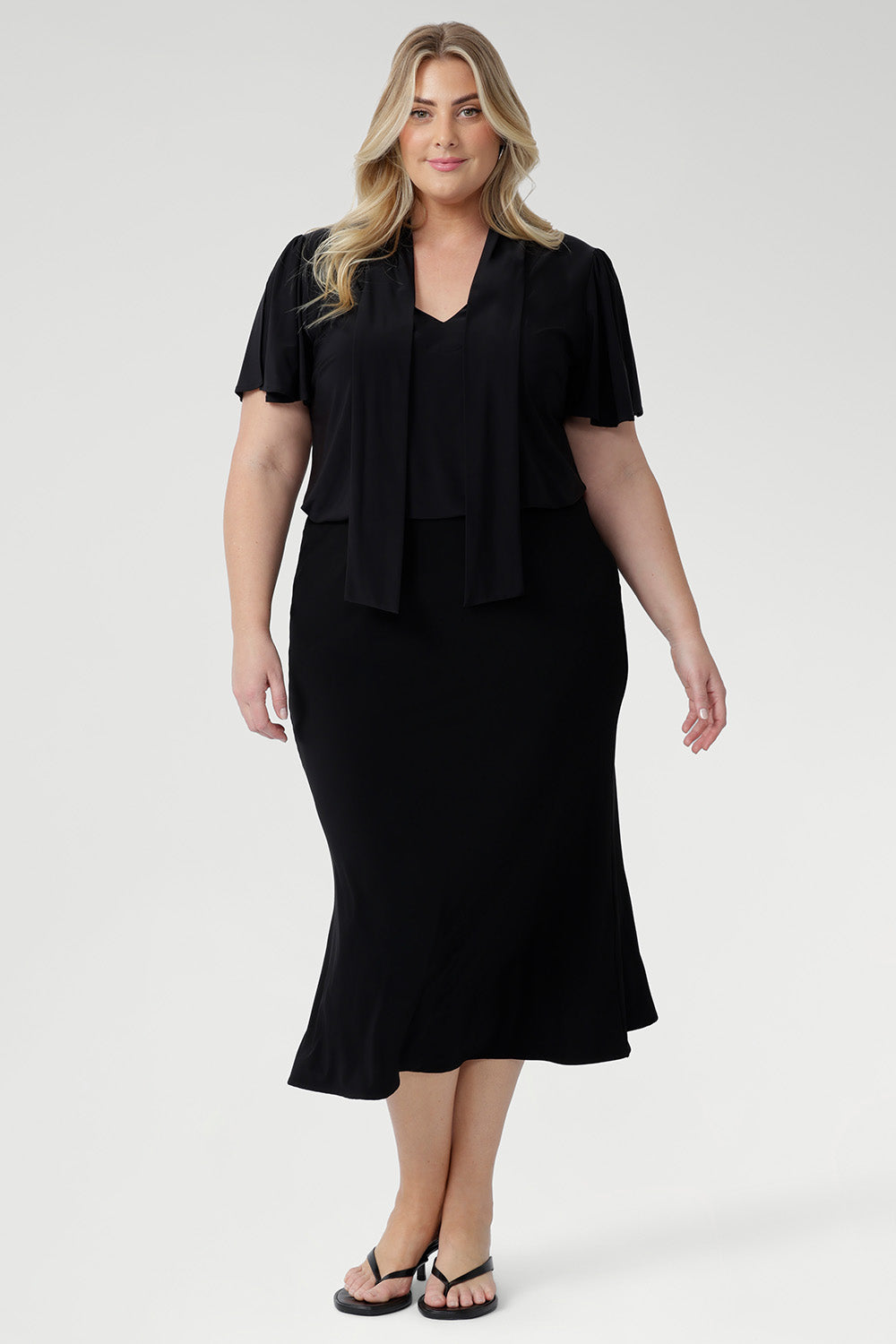. Whether styled for the office, packed for a weekend escape, or dressed up for an evening out, the Michael Top delivers effortless sophistication with every wear. Plus size model wears her Micheal Shirt in Black 