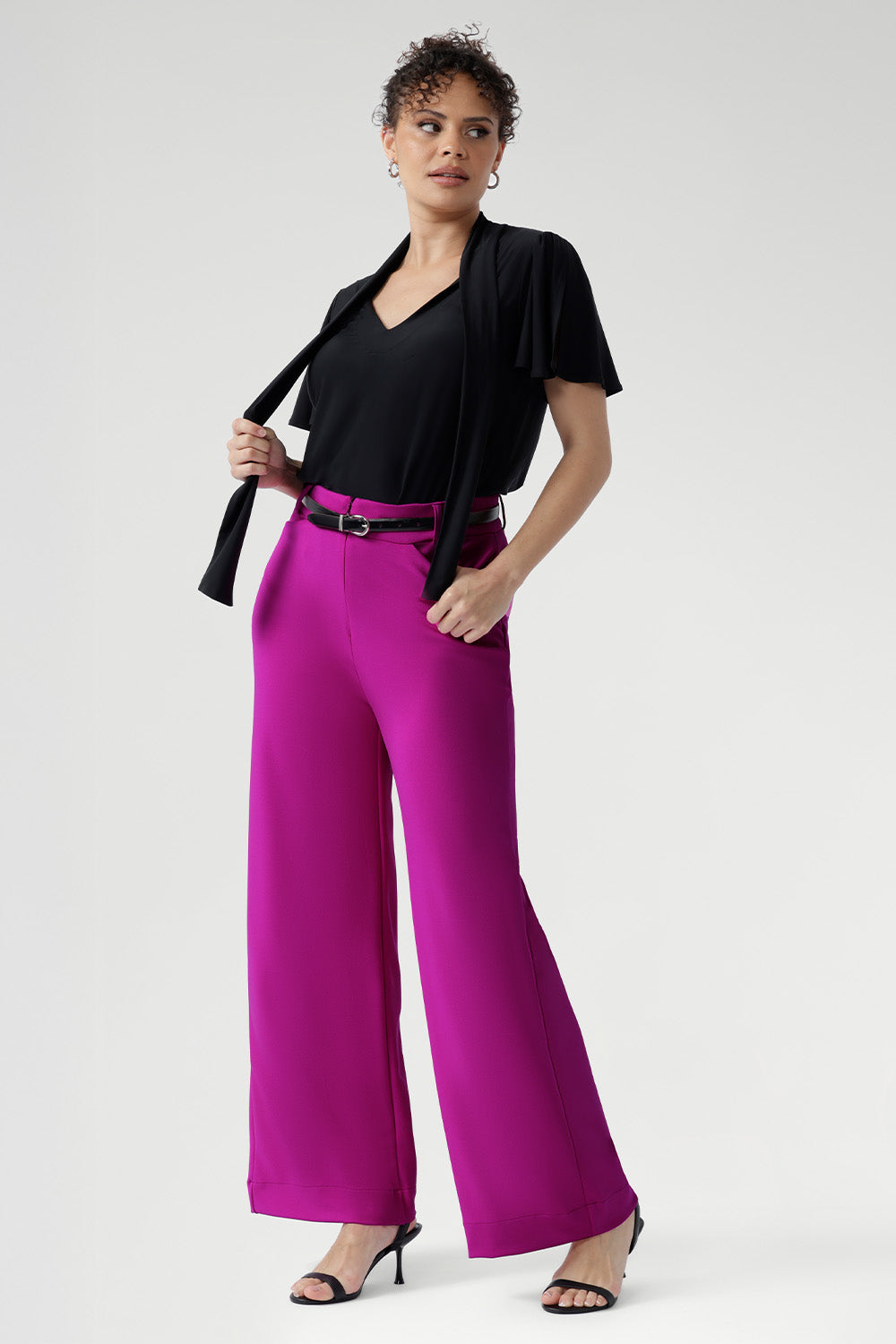 Designed for versatility, it features a soft tie neckline that can be worn loose and relaxed, gently draped, or fastened high for a more polished, elevated look. Short sleeves are subtly gathered at the shoulder and finished with a refined split, offering elegant movement and light coverage without compromising comfort.